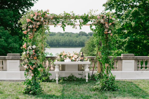 chuppah covered in luxurious greenery and roses on the terrace of the Lilly House at Newfields