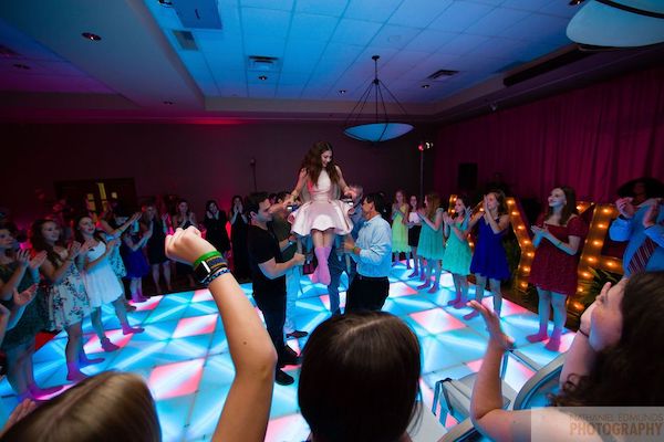 young girl surrounded by family and friends during the hora at her Indianapolis Bat Mitzvah