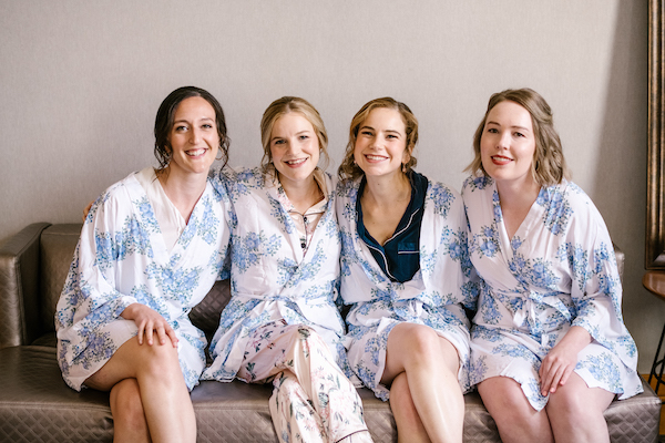 bride and her bridal party in matching blue and white robes
