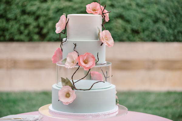 four tiered pistachio wedding cake with glass riser