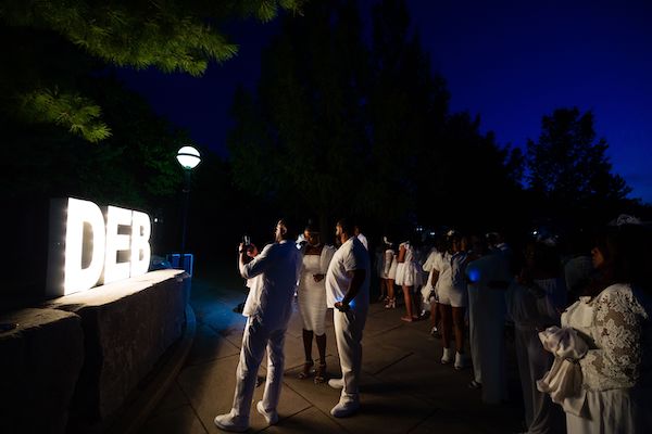 guests in front of the lighted DEB Diner en Blanc sign in Indianapolis