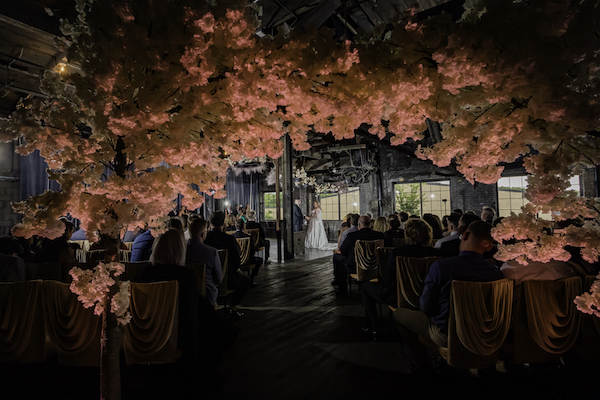 sneak peek of a luxurious Ft Wayne wedding ceremony taken through the luxurious floral arch entry 