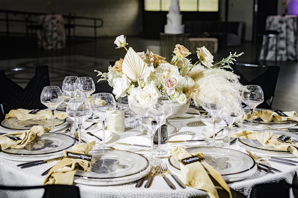 round reception table set with a geometric patterned linen and adorned with a boho style centerpiece