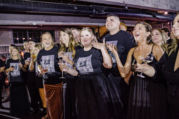 Excited bride, groom and their guests wearing custom concert t-shirts as O-Town sings at their wedding