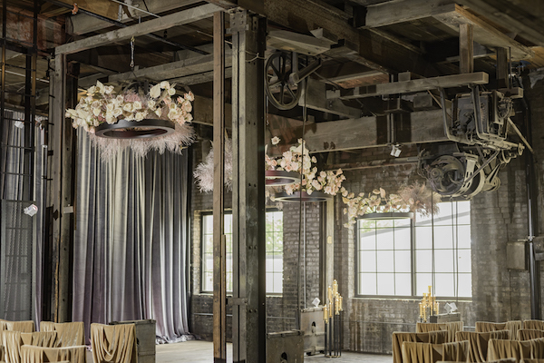 floral chandeliers and luxurious chairs in an industrial event space for a fabulous ft Wayne wedding ceremony