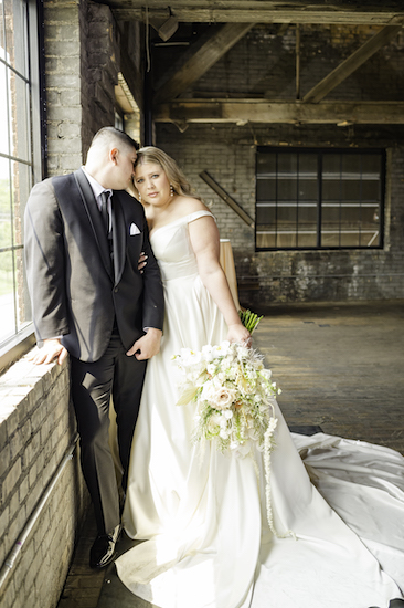 bride and groom posing for wedding photos in an industrial wedding venue before their fabulous Ft Wayne wedding