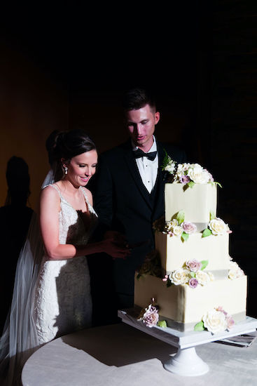 bride and groom cutting their three-tiered square wedding cake