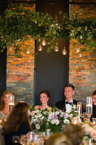 happy newlyweds sitting at their head table of their Indianapolis wedding reception at Canal 337