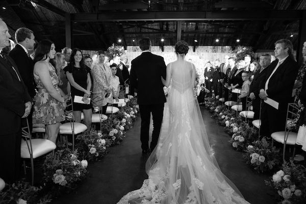 back and white image of a bride walking down the aisle at Canal 337 in Indianapolis