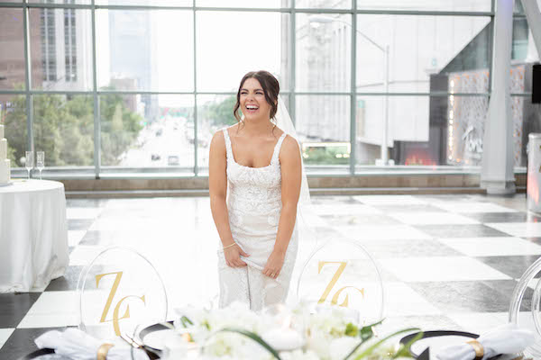 Bride blowna away by her wedding deor and monograammed acrylic reception chairs