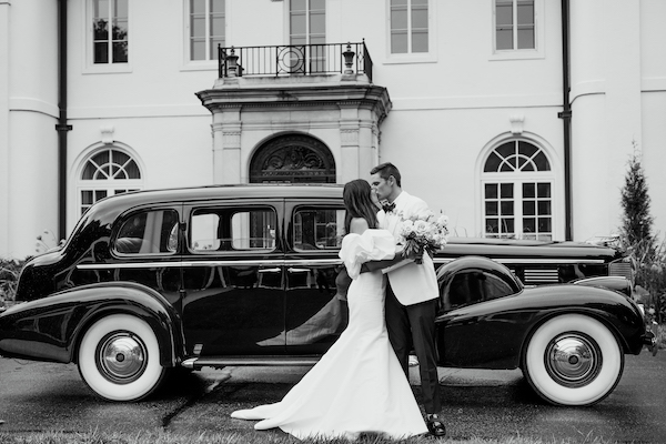 Indianapolis bride and groom taking photos at Newfields with an antique car