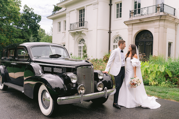 Indianapolis bride and groom taking photos at Newfields with an antique car