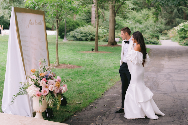 bride and groom take a quick glance at their custom seating chart