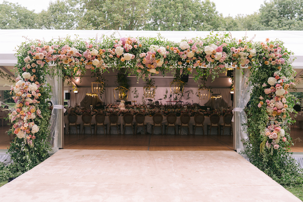 lush floral entrance to a tented garden wedding at Newfields