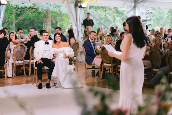 bride and groom sit and enjoy wedding toasts at their Indianapolis wedding reception