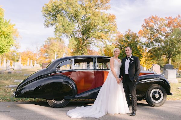 bride and groom taking photos with a vintage Rolls Royce