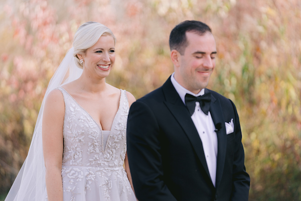 groom as his bride walks behind him for their first look