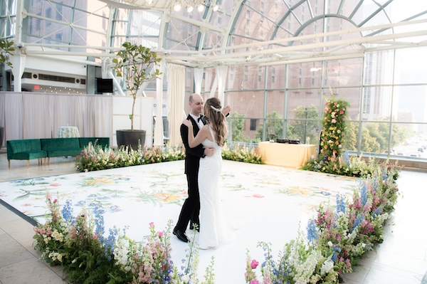 Bride and groom practice their first dance during a sneak peek at their wedding decor