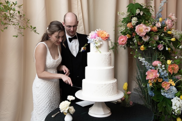 Indianapolis couple cutting their four tiered white wedding cake