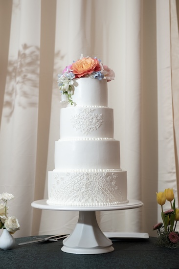 four tiered white wedding cake inspired by the bride's gown