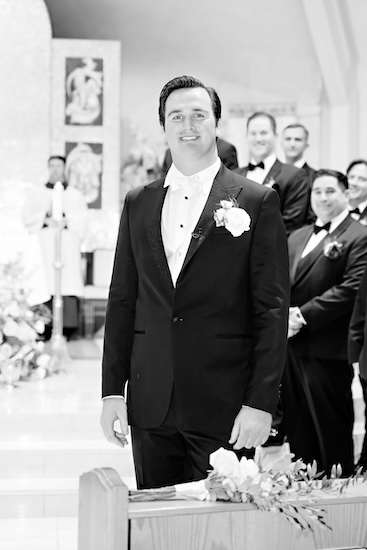 Groom watching anxiously as his bride walks down the aisle