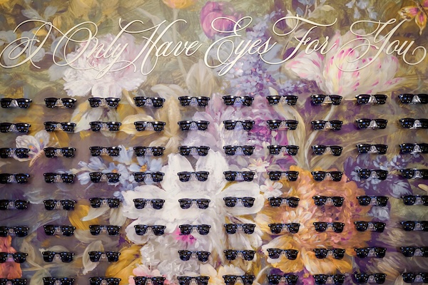 Sunglasses with escort cards attached follow the couple's I only Have Eyes For You theme.