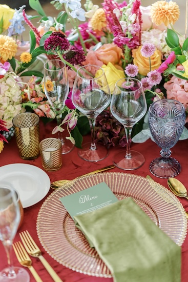 Colorful wedding place setting with vintage inspired glass
