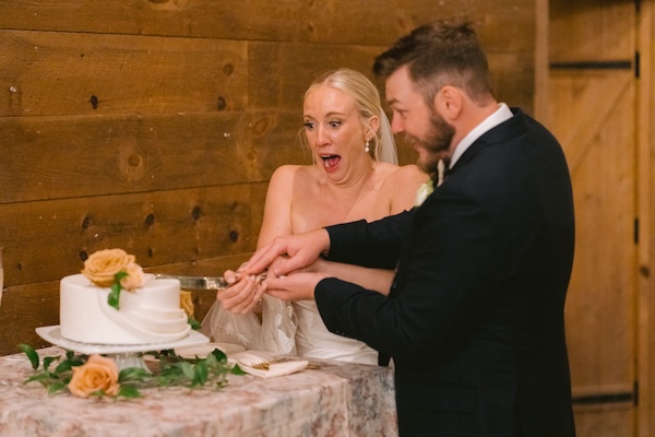 Bride and groom having fun cutting their wedding cake.