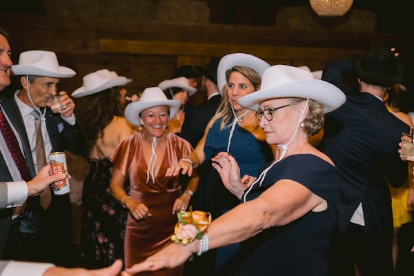 Mother of the briode and guests dancing with cowboy hats during her daughter's Whistling Straits wedding reception.