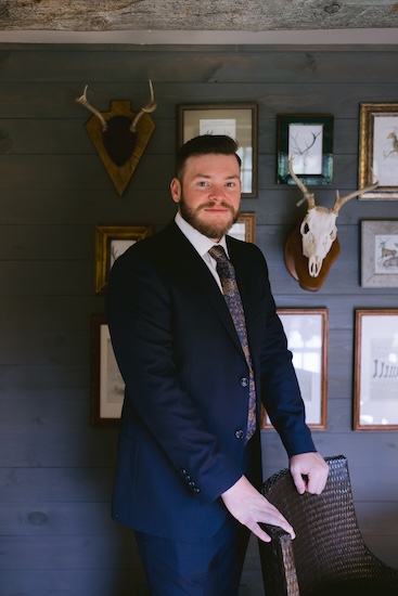 Groom wearing a dark jacket and tie for his Wisconsin destination wedding.