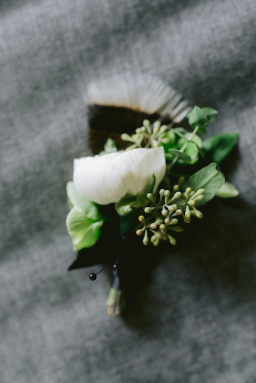 Beautiful rustic floral and feather boutonniere for a groom at his Wisconsin destination wedding