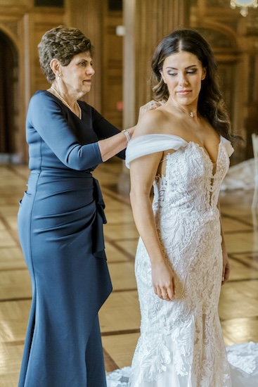 Mother of the bride helping her daughter dress.