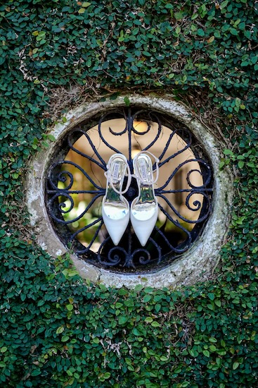 A bride's wedding shoes on a piece of historical wrought iron in Charleston South Carolina