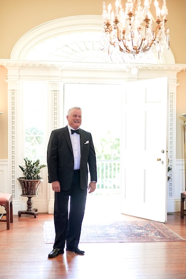 Bride's father waiting for her to come down the stairs 