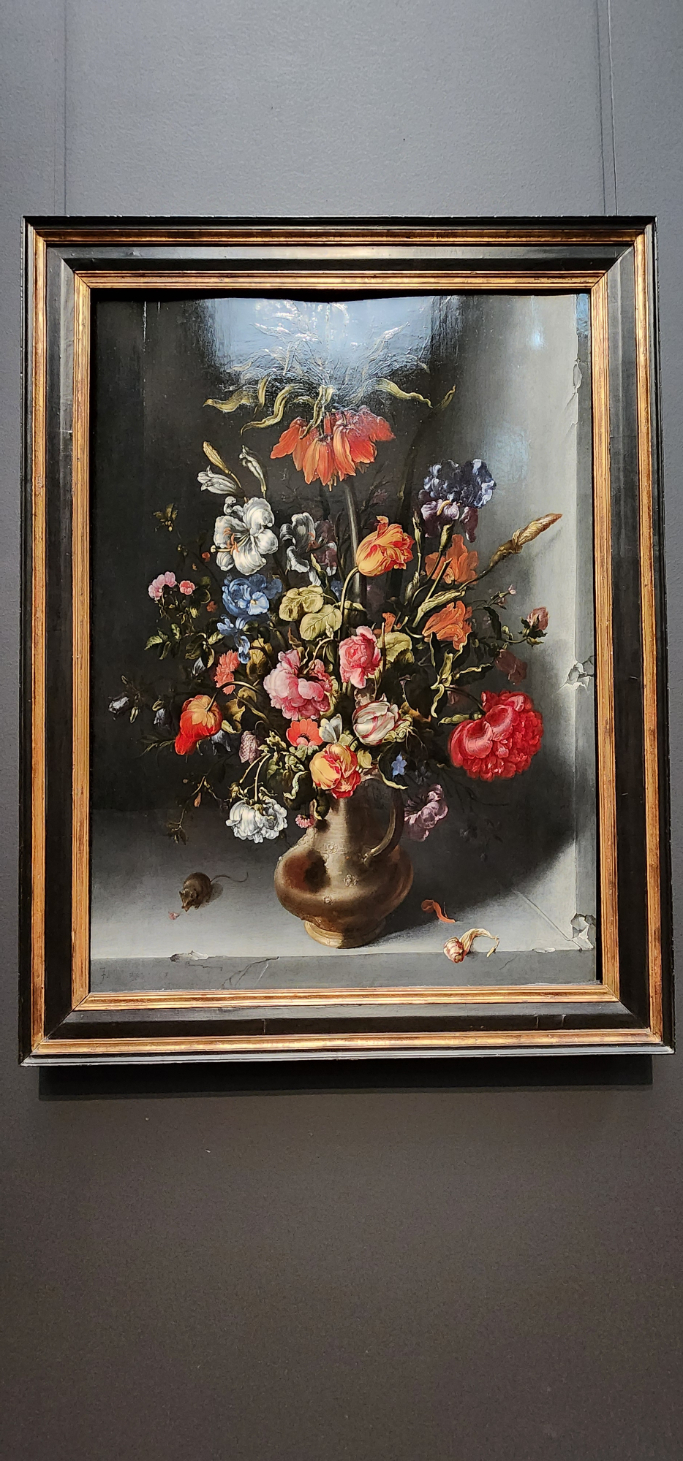 A Dutch Masters painting of a floral arrangement in a dark vase, featuring vibrant flowers, rich colors, and a small mouse at the bottom.