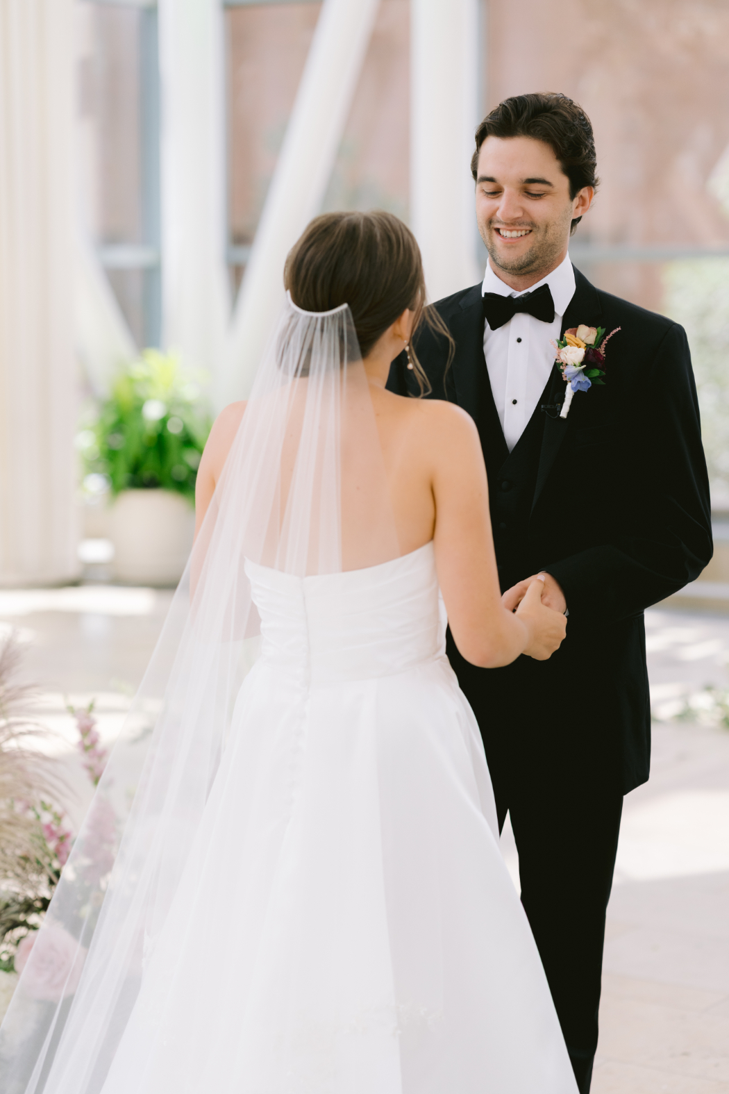 The bride and groom hold hands during their first look.