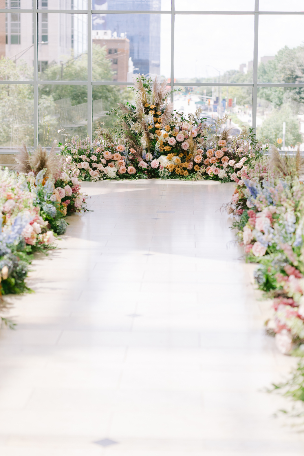 Wedding ceremony aisle decorated with pastel floral arrangements leading to the altar.